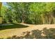 Spacious backyard featuring mature trees, a grassy area, and a concrete patio at 3554 Cherry Bloom Way, Decatur, GA 30034