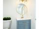 Stylish bathroom vanity with blue cabinets, gold hardware, a round mirror, and modern lighting at 3554 Cherry Bloom Way, Decatur, GA 30034