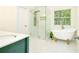 Bright bath with gold shower, clawfoot tub, and marble flooring at 3554 Cherry Bloom Way, Decatur, GA 30034