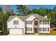 Charming two-story home with a two-car garage, stone accents and inviting curb appeal nestled amongst mature trees at 3554 Cherry Bloom Way, Decatur, GA 30034