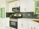 Modern kitchen with stainless steel appliances, dark backsplash, and white cabinets with gold accents at 3554 Cherry Bloom Way, Decatur, GA 30034