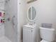Bright bathroom features a shower with marble-patterned walls and white vanity with modern fixtures at 4699 Ballew Dr, Powder Springs, GA 30127