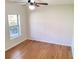 Well-lit bedroom featuring gleaming hardwood floors, a ceiling fan and a window at 528 Lantern Wood Dr, Scottdale, GA 30079