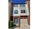 Attractive two-story townhome with blue door, attached garage, and brick accents at 528 Lantern Wood Dr, Scottdale, GA 30079