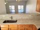 Modern kitchen with breakfast bar, stainless steel sink, and view into the living room at 528 Lantern Wood Dr, Scottdale, GA 30079