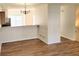 Bright and airy living area featuring modern light fixtures and wood flooring with view to kitchen at 528 Lantern Wood Dr, Scottdale, GA 30079