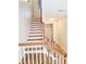 Bright staircase with white risers, hardwood treads, and stylish wooden railing at 528 Lantern Wood Dr, Scottdale, GA 30079