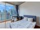 Bedroom featuring a large window with expansive city views and a cozy, comfortable bed at 860 Peachtree Ne St # 1010, Atlanta, GA 30308