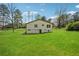 Back of the home showing a large yard with lush grass and mature trees at 961 Old Conyers Rd, Stockbridge, GA 30281