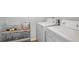 Bright laundry room with white washer and dryer units and a metal shelving unit at 961 Old Conyers Rd, Stockbridge, GA 30281
