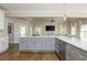 Open-concept kitchen boasts gray cabinets, stainless appliances, and quartz countertops, flowing into the living room at 10575 Wren Ridge Rd, Alpharetta, GA 30022