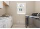 Well-lit laundry room features white cabinetry, marble counters and a stainless steel front-loading washer and dryer at 10575 Wren Ridge Rd, Alpharetta, GA 30022