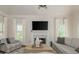 Bright living room featuring a fireplace with marble surround, a large TV, and comfortable seating at 10575 Wren Ridge Rd, Alpharetta, GA 30022