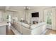 Cozy living room with a fireplace, large TV, and hardwood floors, seamlessly connected to the kitchen at 10575 Wren Ridge Rd, Alpharetta, GA 30022