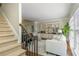 Bright living room leads to staircase and features a piano and built in bookshelves at 10575 Wren Ridge Rd, Alpharetta, GA 30022