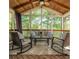 Cozy screened porch with comfortable seating, ceiling fan, and wooded views at 10575 Wren Ridge Rd, Alpharetta, GA 30022