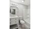Clean bathroom with white fixtures, marble floors, and a vanity with sink and mirror at 1753 Detroit Nw Ave, Atlanta, GA 30314