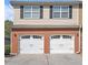 A two-car garage features white doors and brick siding, complementing the home's classic exterior at 1960 Dakota Nw Dr, Acworth, GA 30101