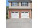 A two-car garage features white doors and brick siding, complementing the home's classic exterior at 1960 Dakota Nw Dr, Acworth, GA 30101