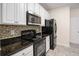 Modern kitchen featuring black appliances, granite countertops, and white cabinets at 1960 Dakota Nw Dr, Acworth, GA 30101