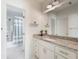 Bathroom with white cabinets, granite countertop, shower and tub behind glass door at 5138 Price Dr, Suwanee, GA 30024