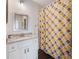 Bright bathroom features a vanity with granite countertop and a shower with a patterned curtain at 5138 Price Dr, Suwanee, GA 30024