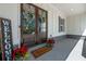 Inviting front porch featuring double doors, a 'Welcome' mat, and potted red flowers at 5138 Price Dr, Suwanee, GA 30024