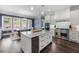 Bright kitchen featuring a large island, stainless steel appliances, and hardwood floors, adjacent to dining area at 5138 Price Dr, Suwanee, GA 30024