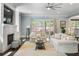 Bright living room with a cozy fireplace, lots of seating, and sliding glass doors to the yard at 5138 Price Dr, Suwanee, GA 30024