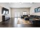 Living room area with large sectional sofa, television, and hardwood flooring at 5138 Price Dr, Suwanee, GA 30024