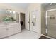 Bright bathroom featuring double sinks, white cabinets, and a glass-enclosed shower at 1020 Burton Ne Dr, Atlanta, GA 30329
