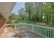 Brick-lined backyard with mature trees, white fence, and view of lush landscape at 1093 Lanier Sw Dr, Marietta, GA 30060