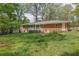 View of the backyard of the brick home with patio and small white shed at 1093 Lanier Sw Dr, Marietta, GA 30060