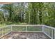 Spacious backyard with lush trees and a white fenced concrete patio at 1093 Lanier Sw Dr, Marietta, GA 30060