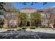 Three-story brick building with symmetrical design, mature trees, manicured bushes, and street access at 978 North Ne Ave # 207, Atlanta, GA 30306