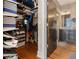 Well-organized walk-in closet featuring custom shelving and rods, plus an adjacent bathroom with stone wall and dark wood cabinets at 978 North Ne Ave # 207, Atlanta, GA 30306