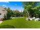 A spacious backyard with green grass, a pool, an outdoor fireplace, and lush greenery at 1116 Dan Johnson Ne Rd, Atlanta, GA 30307