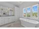 Bright bathroom features a soaking tub, large windows, and double vanity with large mirrors at 1116 Dan Johnson Ne Rd, Atlanta, GA 30307