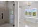 Luxurious bathroom with soaking tub, shower, large windows, and elegant chandelier at 1116 Dan Johnson Ne Rd, Atlanta, GA 30307