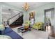 Elegant living room with a cozy fireplace, unique artwork, and hardwood floors seamlessly transitioning to the staircase at 1116 Dan Johnson Ne Rd, Atlanta, GA 30307