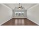 Light-filled bedroom featuring tray ceiling, ceiling fan, and three large windows at 348 Ellington Dr, Canton, GA 30115