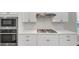 Close up of a modern kitchen with stainless steel appliances, white cabinets, and stone backsplash at 348 Ellington Dr, Canton, GA 30115