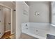 Bright bathtub featuring white subway tile surround and adjacent storage at 373 Hidden Creek Ln, Canton, GA 30114