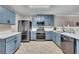 Modern kitchen with blue cabinets, stainless steel appliances, and white countertops for a clean, stylish look at 373 Hidden Creek Ln, Canton, GA 30114