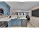 Well-lit kitchen offering stainless appliances, blue cabinets, and open access to adjacent dining and living spaces at 373 Hidden Creek Ln, Canton, GA 30114