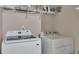 Bright laundry room with front loading washer and dryer and wire rack shelving at 373 Hidden Creek Ln, Canton, GA 30114