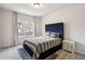 Cozy bedroom with a tufted headboard, soft grey bedding, and ample natural light from the window at 375 Crider Ct, Woodstock, GA 30188
