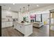 Open-concept living room with white cabinets, granite counters, and island with pendant lighting, flowing into a cozy living area at 375 Crider Ct, Woodstock, GA 30188