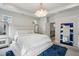 Spacious main bedroom with a tufted headboard, modern chandelier, and bright, natural light at 375 Crider Ct, Woodstock, GA 30188