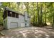 Large home with a three-car garage nestled in a wooded lot with a driveway at 7470 Princeton Trce, Sandy Springs, GA 30328